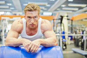 Man gets some rest between exercises in gym hall